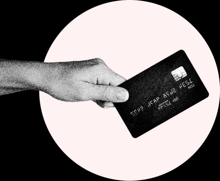 Mão segurando um cartão de crédito, com círculo rosa em background